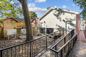 Grove II house with a white fence and a black railing.