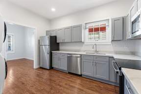 Grove Place II kitchen with wooden floors and stainless steel appliances.