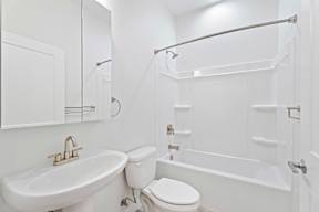 Grove Place II white bathroom with a toilet, sink, and bathtub.
