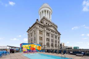 A large building with a dome on top is surrounded by a pool.
