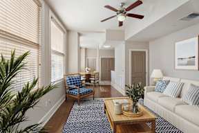 A living room with a blue rug and a wooden coffee table.