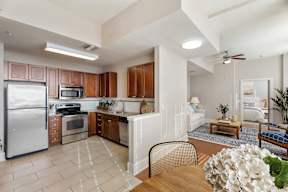 A kitchen with a refrigerator, oven, and sink.