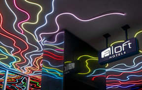 A colorful neon sign for Aloft Hotels.