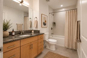 A bathroom with a toilet, sink, and shower.