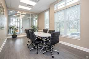A conference room with a table and chairs.