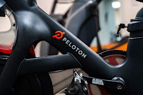 A close up of a black bicycle frame with the word Peloton written on it.