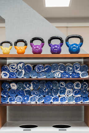 A shelf with kettlebells and towels.