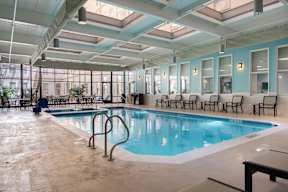 A large indoor swimming pool with a skylight above it.