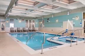 A large indoor swimming pool with a diving board.
