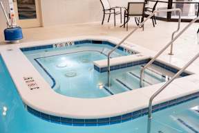 A hot tub with a blue tiled edge and a white interior.