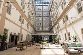 A large atrium with a glass ceiling and furniture.