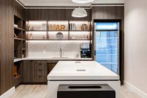 A modern kitchen with a white countertop and wooden cabinets.