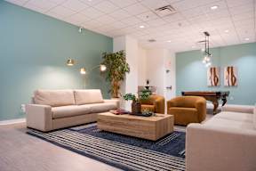 A living room with a sofa, armchair, and coffee table.