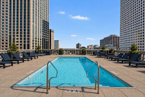 A rectangular pool with a metal diving board on a rooftop.