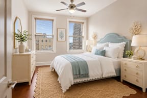 A bedroom with a bed, dresser, and mirror.