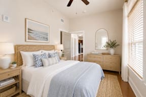 A bedroom with a large bed and a painting on the wall.
