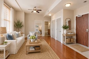 A well-lit living room with a white sofa and a wooden coffee table.
