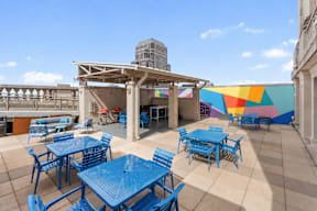 A patio with blue tables and chairs.