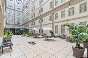 A patio with a table and chairs and a potted plant.
