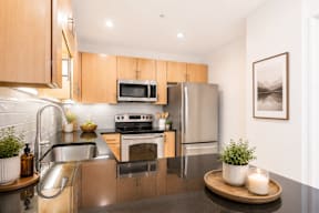 A modern kitchen with a stainless steel sink and wooden cabinets.