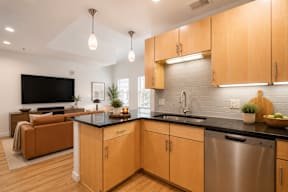 A modern kitchen with wooden cabinets and a black countertop.