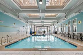 A large indoor swimming pool with a glass ceiling.