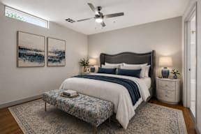 A bedroom with a large bed and a ceiling fan.