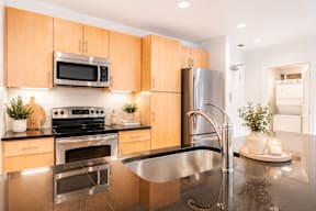 A modern kitchen with wooden cabinets and stainless steel appliances.