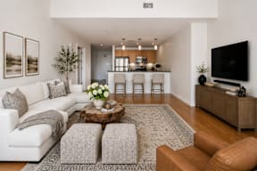 A modern living room with a white sofa, a coffee table, and a television.