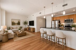 A modern kitchen with a bar area and a living room with a couch and a coffee table.