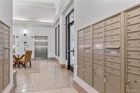 A hallway with a table and chairs and mailboxes on the wall.