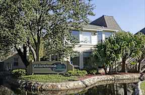 A house with a sign that says Willowbrook in front of it.