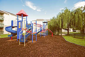 A playground with a blue slide and a red roof.