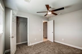a bedroom with a ceiling fan and closet