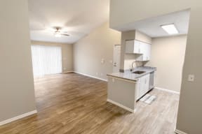 an empty room with a kitchen and a living room