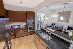 a kitchen with granite countertops and stainless steel appliances