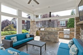 a covered patio with blue couches and a stone wall