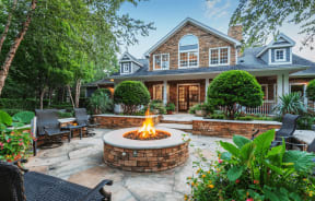 a backyard with a fire pit and patio furniture