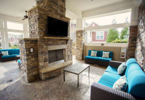 the living room has a large stone fireplace and blue couches