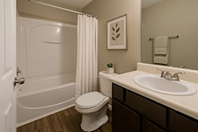 A white toilet sits next to a white sink in a bathroom.