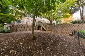 the backyard of a brick building with trees and a staircase