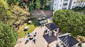 A bird's eye view of a backyard with a gazebo, lawn chairs, and a fire pit. at The Point at Perimeter, Georgia, 30338