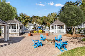 A gazebo surrounded by blue chairs and a brick walkway. at The Point at Perimeter, Georgia, 30338