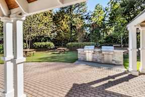 A patio with a white column and a stone wall. at The Point at Perimeter, Georgia, 30338