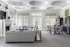 a living room with a coffered ceiling and a fireplace