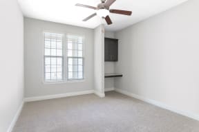 a bedroom with a ceiling fan and a window