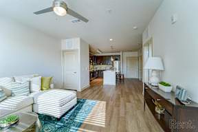 A living room with a white couch and a ceiling fan.