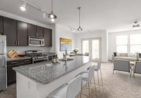 A modern kitchen with a granite countertop and stainless steel appliances.