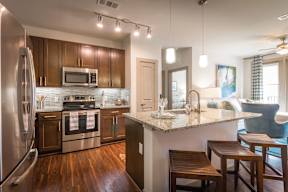 A modern kitchen with wooden cabinets and a granite countertop.