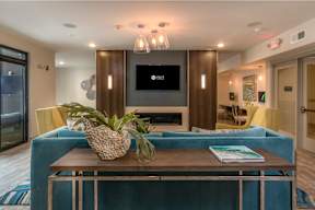 A living room with a blue couch and a wooden coffee table.